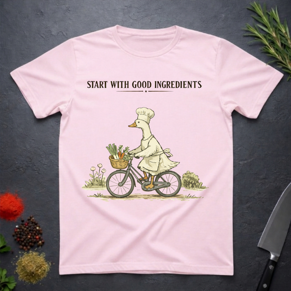 Light Pink t-shirt with a graphic of a goose chef riding a bike with vegetables in basket. Text "Start with Good Ingredients" above graphic. 