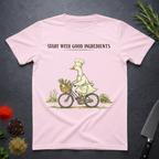 Light Pink t-shirt with a graphic of a goose chef riding a bike with vegetables in basket. Text "Start with Good Ingredients" above graphic. 