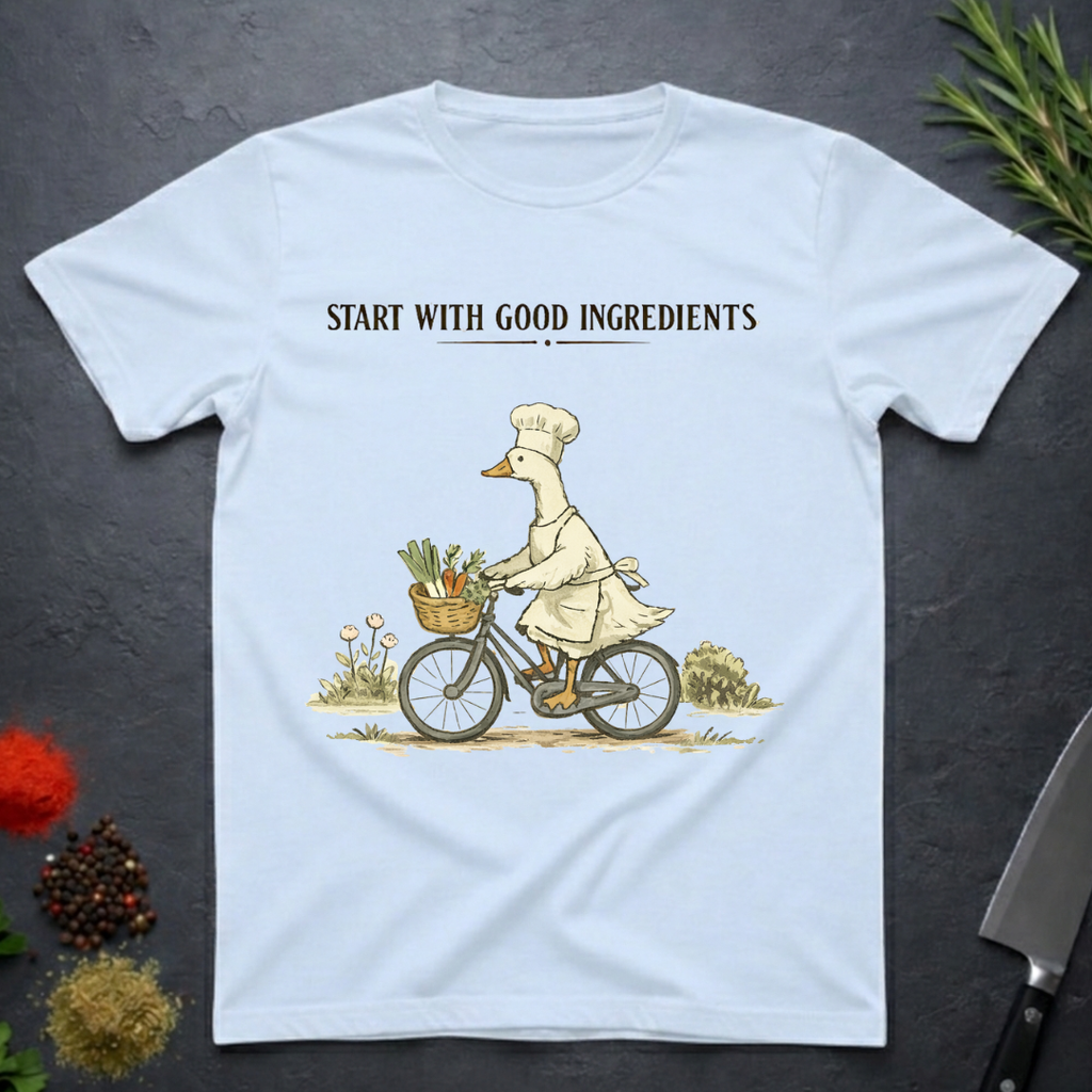 Light Blue t-shirt with a graphic of a goose chef riding a bike with vegetables in basket. Text "Start with Good Ingredients" above graphic. 