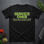 Black t-shirt with green text "Service Over-Press Start for Next Shift" on a dark surface.