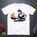 White t-shirt with a graphic of a chef and 'Line Cook Energy' text on a dark surface with kitchen items.