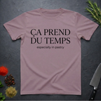 Paragon colored t-shirt with text 'ÇA PREND DU TEMPS especially in pastry' on a dark surface with kitchen items.