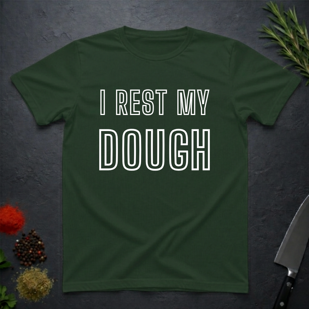 Forest Green t-shirt with 'I Rest My Dough' text on a dark surface with decorative elements.