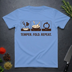 Carolina blue t-shirt with chocolate-making diagram and text 'Temper. Fold. Repeat.' on a dark surface.