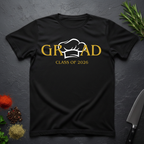 Black t-shirt with gold text 'GRAD Class of 2026' and a centered Chef's Toque design on a dark surface with decorative elements.
