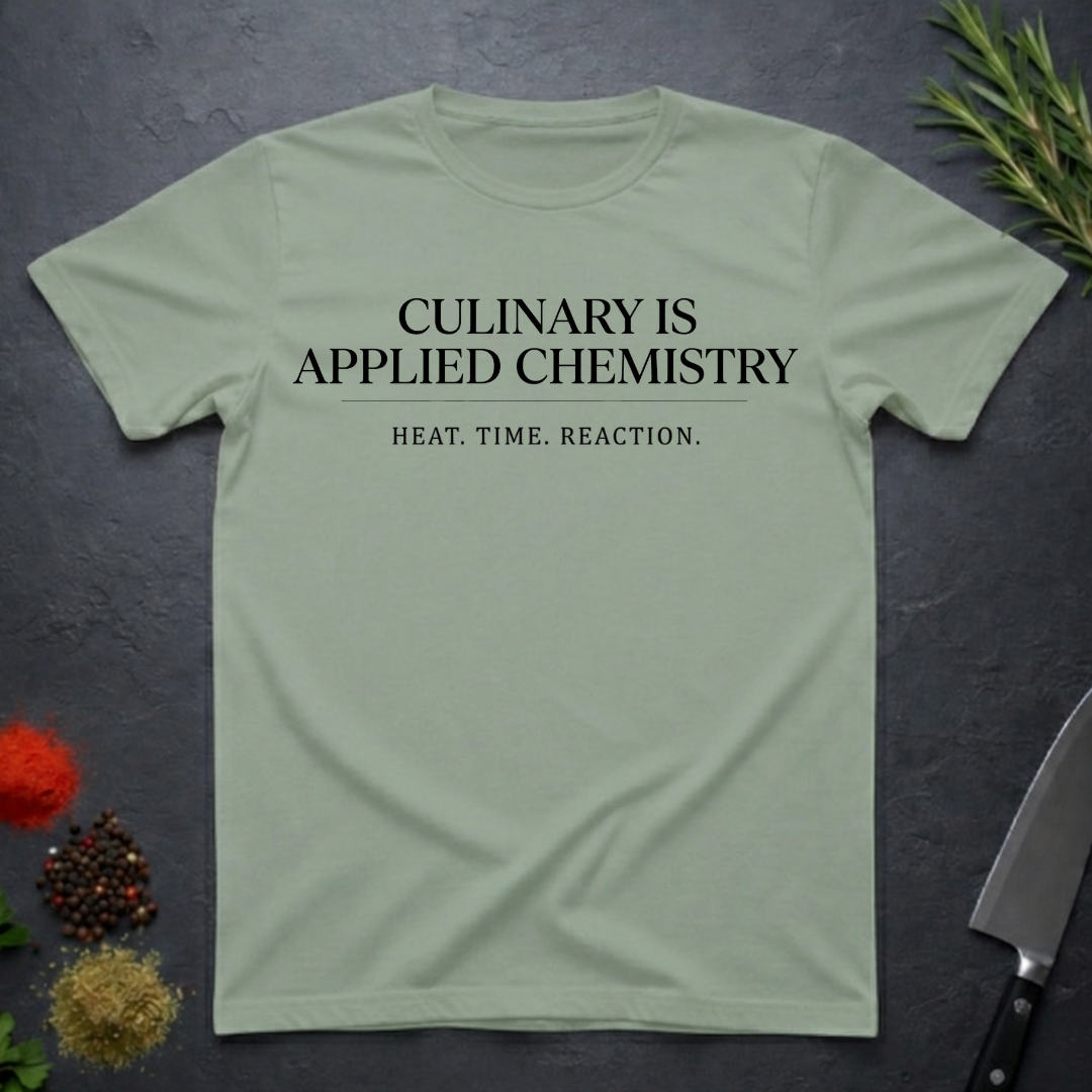 Sage Green t-shirt with black text on a dark surface with kitchen items.
