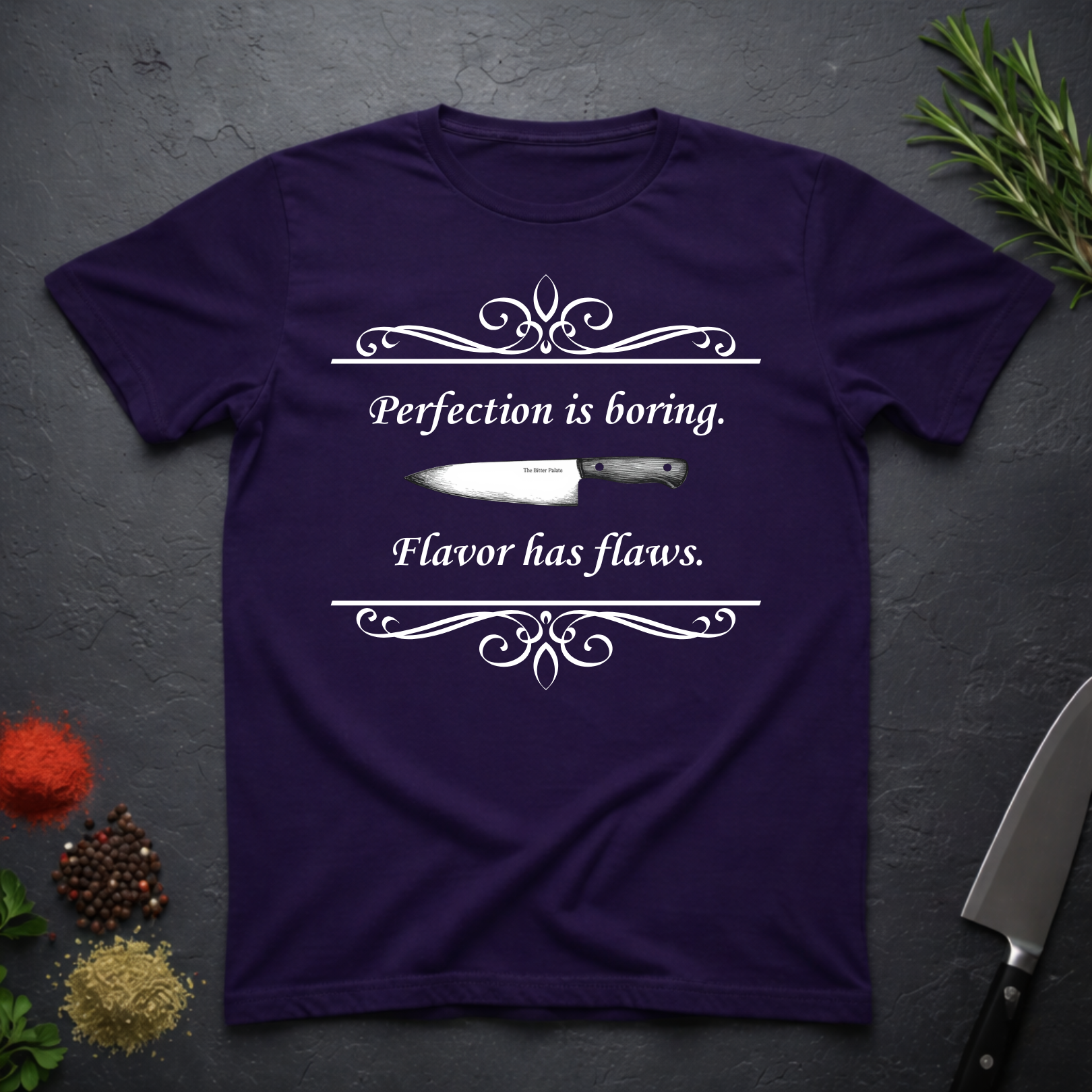 Amethyst purple t-shirt with a knife graphic and text "Perfection is boring. Flavor has flaws." On a dark surface. 