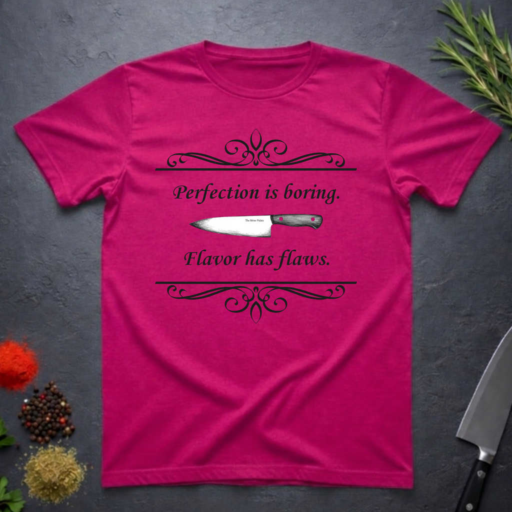 Antique Heliconia pink t-shirt with a knife graphic and text "Perfection is boring. Flavor has flaws." On a dark surface. 