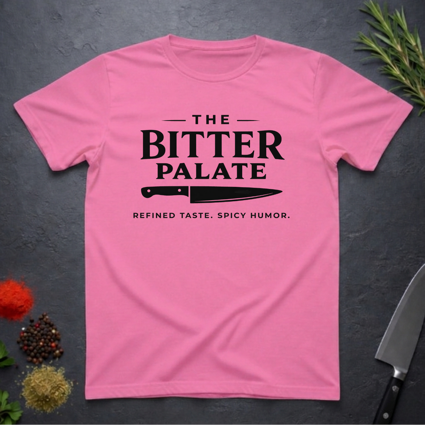 Azalea t-shirt with 'The Bitter Palate' logo on a dark surface with kitchen items.