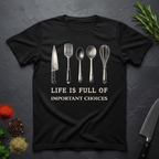 Black t-shirt with kitchen utensil graphics and text "Life is Full of Important Choices" on a dark surface.