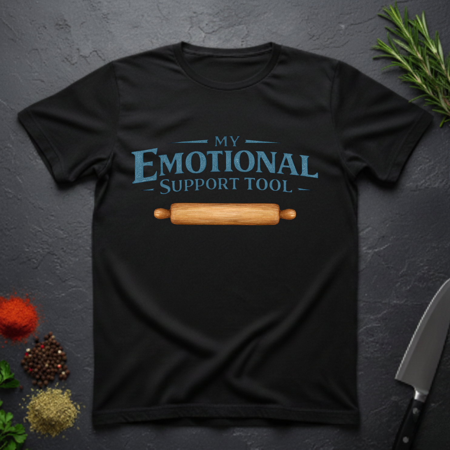 Black t-shirt with 'My Emotional Support Tool' text and rolling pin graphic on a dark surface.