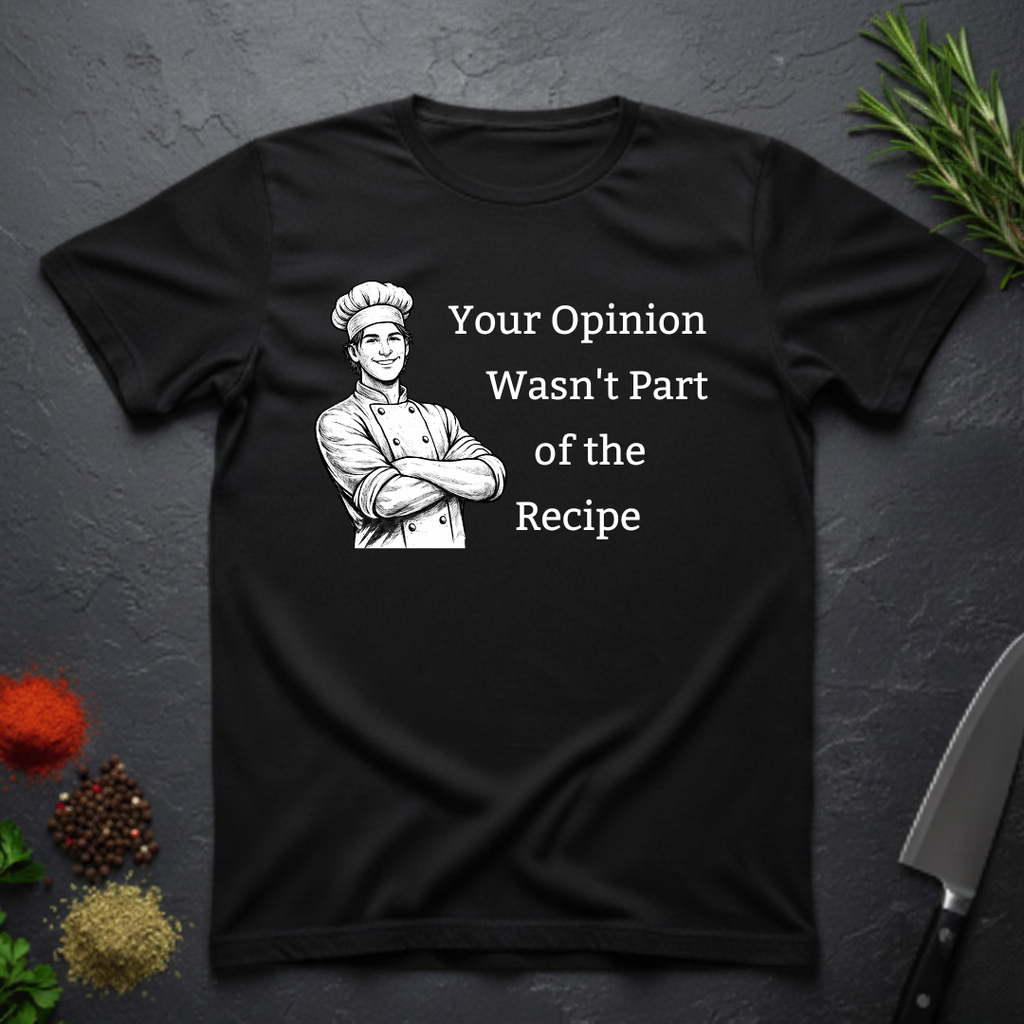 Black t-shirt with a male chef graphic and text "Your Opinion Wasn't Part of the Recipe" on a dark surface with kitchen items.