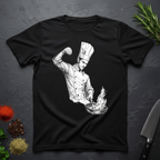 Black t-shirt with a artistic graphic of a chef sprinkling salt into a pan with fire on a dark surface with kitchen items.
