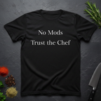 Black t-shirt with 'No Mods Trust the Chef' text on a dark surface with kitchen items.