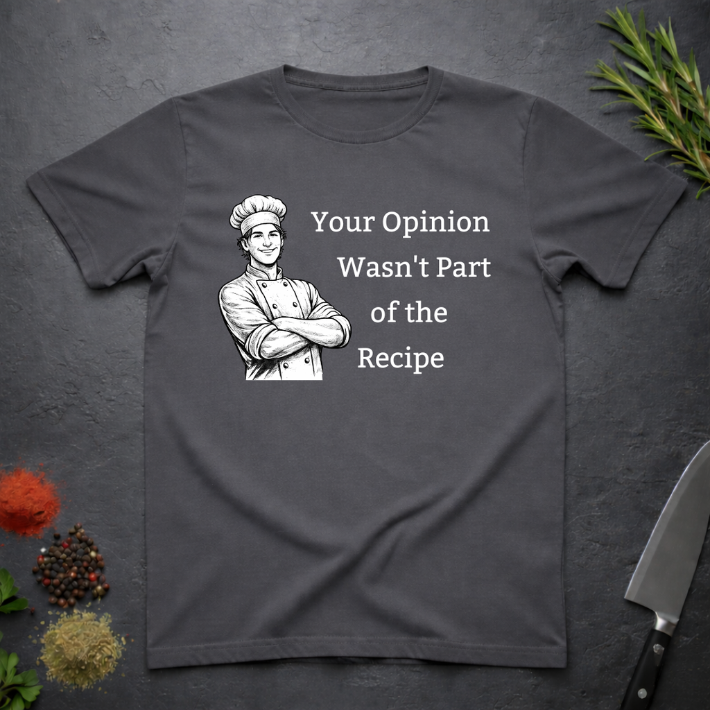 Charcoal grey t-shirt with a male chef graphic and text "Your Opinion Wasn't Part of the Recipe" on a dark surface with kitchen items.