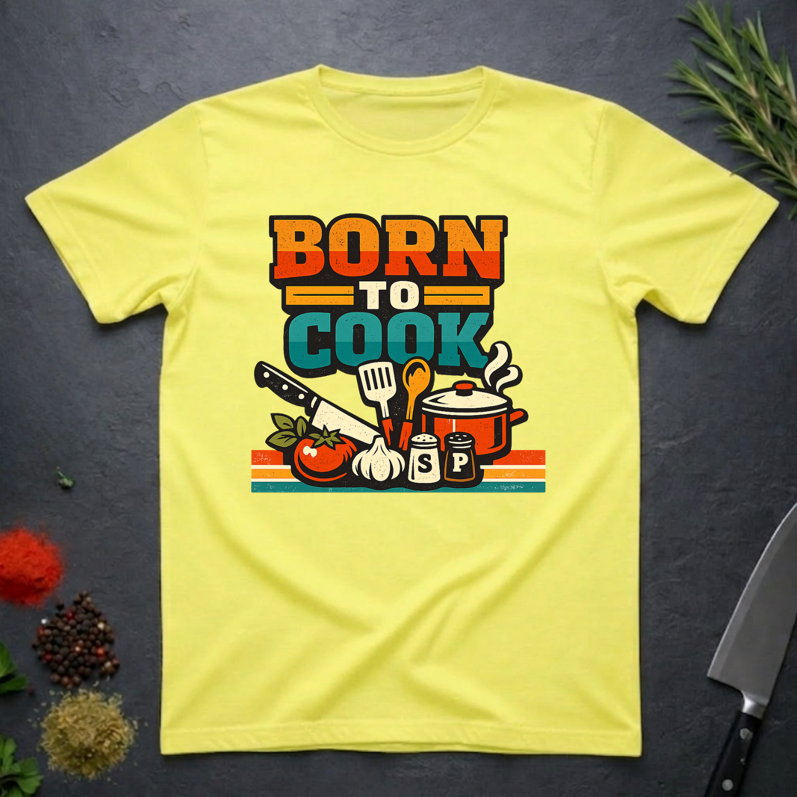 Cornsilk Yellow t-shirt with 'Born to Cook' graphic design on a dark surface.