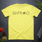 Cornsilk yellow t-shirt with black icons of chef hat, game remote, ramen bowl and repeat symbol on a dark surface.