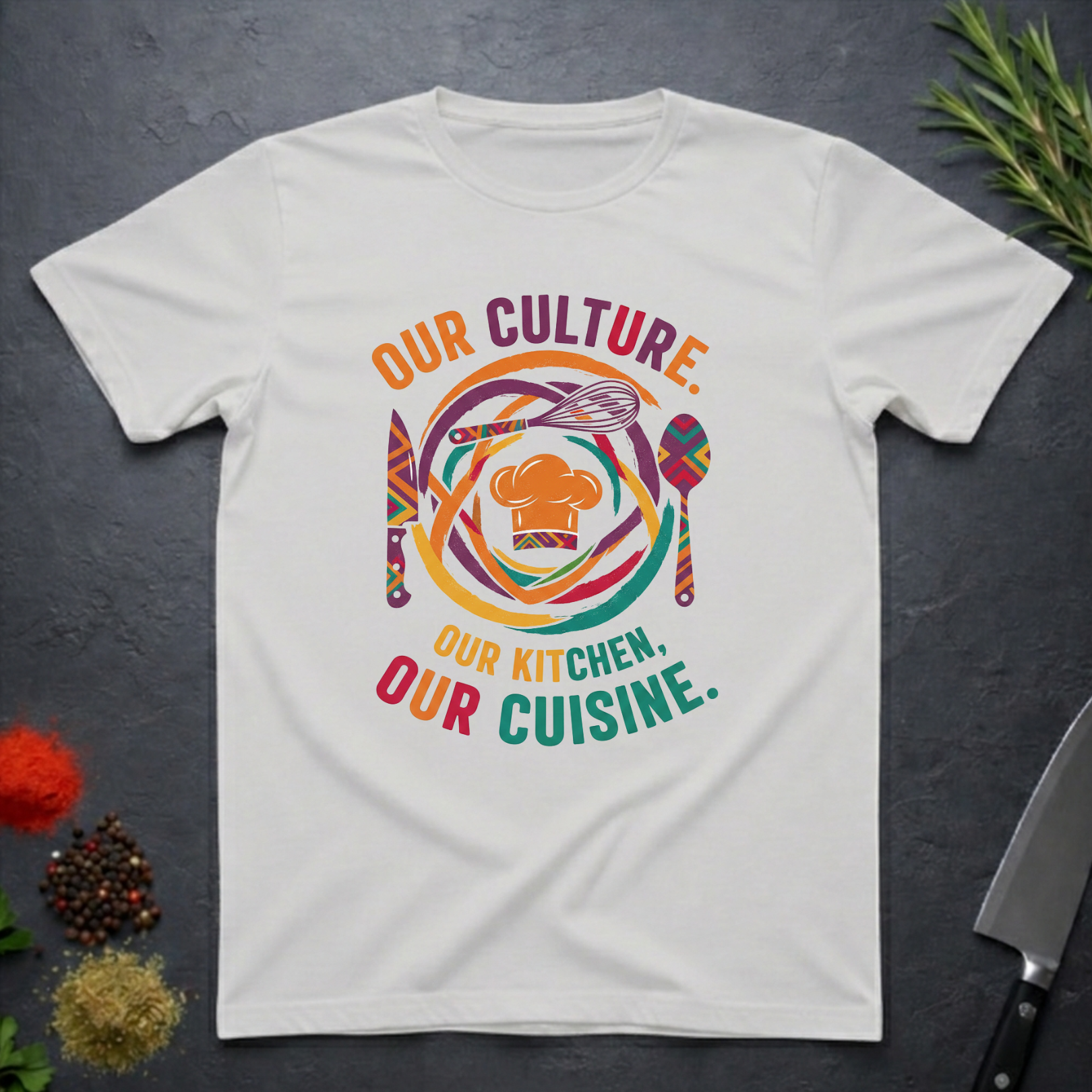 Ice grey t-shirt with colorful African graphic and text "Our Culture Our Kitchen, our Cuisine: on a dark surface.