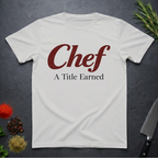 Ice Grey t-shirt with 'Chef A Title Earned' text on a dark surface with kitchen items.