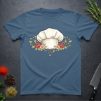 Indigo Blue t-shirt with a chef's hat and floral design on a dark surface.