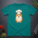 Jade Dome colored t-shirt with an orange cartoon cat wearing a chef's hat on a dark surface.