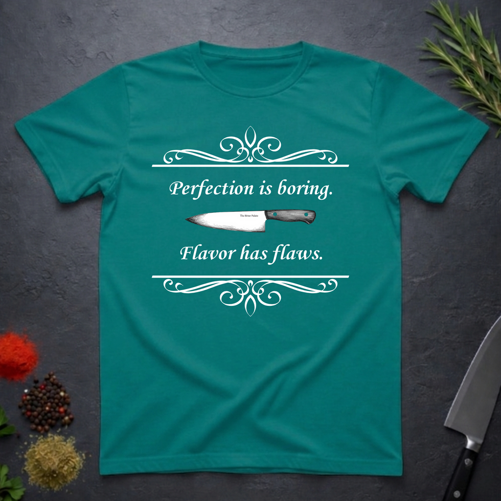 Jade dome colored t-shirt with a knife graphic and text "Perfection is boring. Flavor has flaws." On a dark surface. 