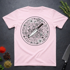 Light pink t-shirt with a circular floral and knife design on a dark surface.