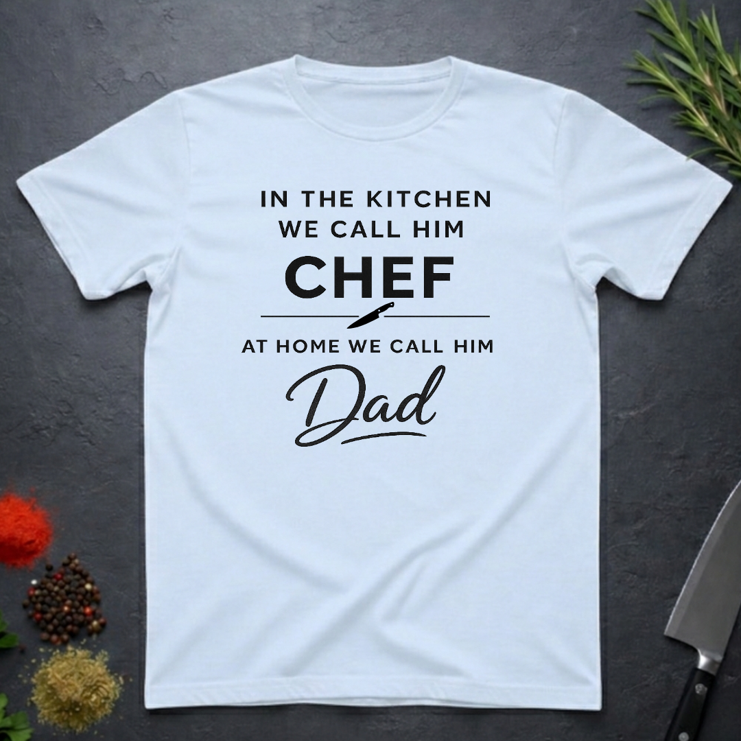 Light Blue t-shirt for Father's with text "In the kitchen we call him Chef - At home we call him Dad" on a dark surface.