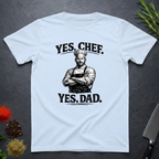 Light blue t-shirt with a graphic of a chef and text 'YES, CHEF. YES, DAD.' on a dark surface.