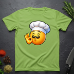 Lime Green t-shirt with a chef kiss emoji design on a dark surface with kitchen items.