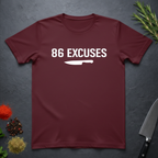 Maroon t-shirt with '86 Excuses' and a knife graphic on a dark surface.