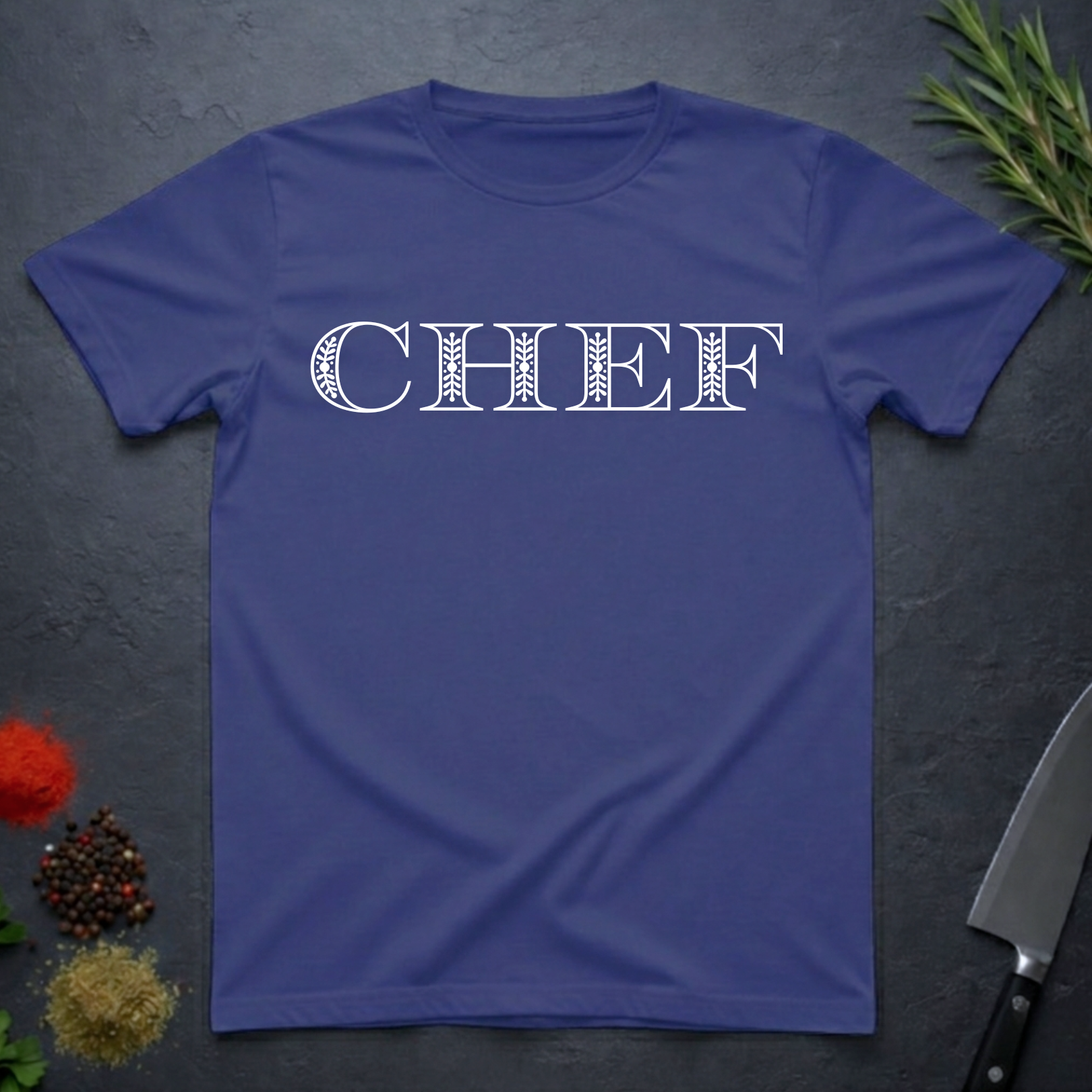 Metro Blue t-shirt with 'CHEF' printed in a decorative serif text on a dark surface with kitchen items.