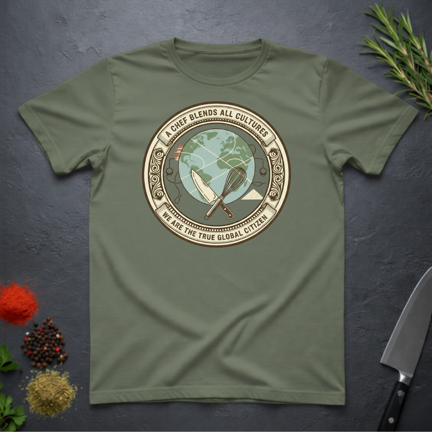 Military green t-shirt with circular graphic of a globe and text "A Chef Blends All Cultures" on a dark surface.