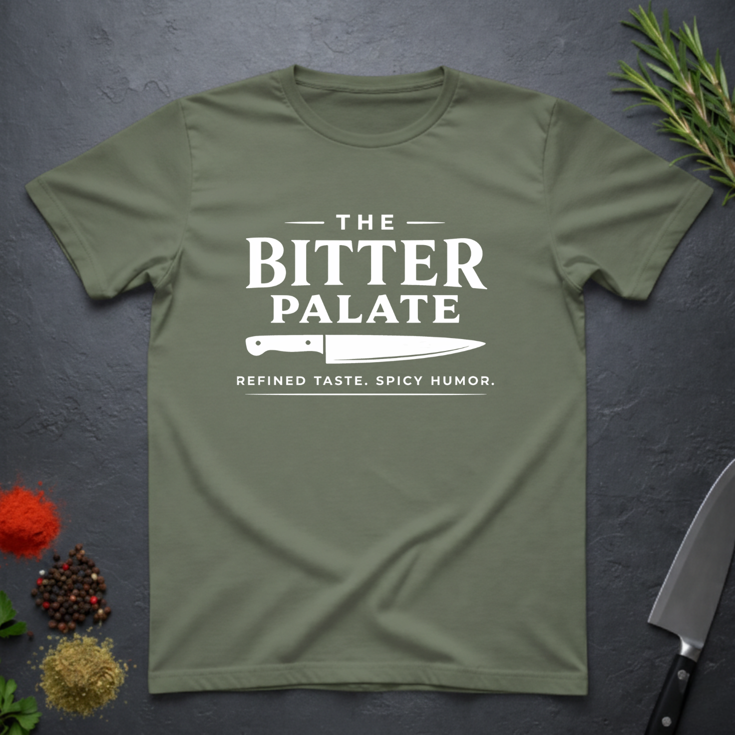 Military Green t-shirt with 'The Bitter Palate' logo on a dark surface with kitchen items.