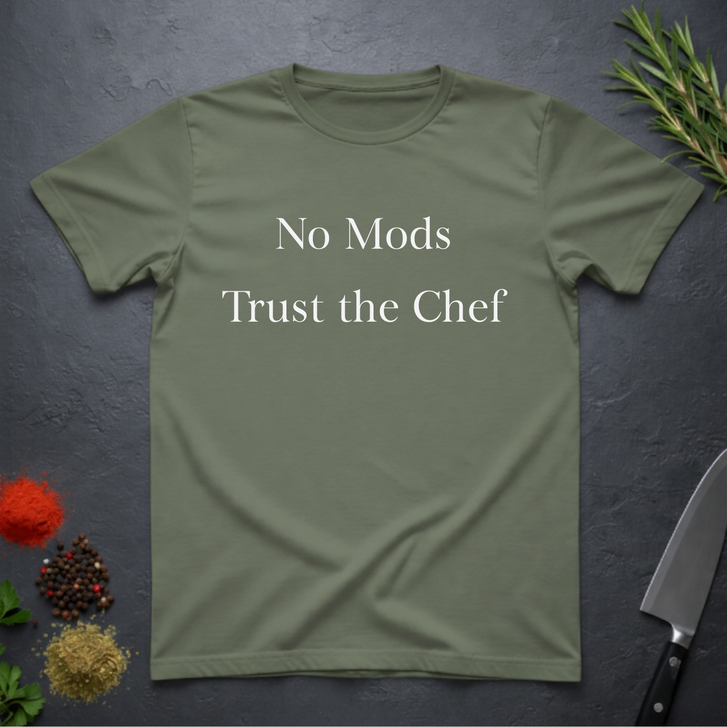 Military Green t-shirt with 'No Mods Trust the Chef' text on a dark surface with kitchen items.