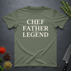 Green t-shirt with 'CHEF FATHER LEGEND' text on a dark surface with kitchen items.
