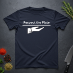 Navy blue t-shirt with 'Respect the Plate' graphic on a dark surface with kitchen items.