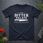 Navy Blue t-shirt with 'The Bitter Palate' logo on a dark surface with kitchen items.
