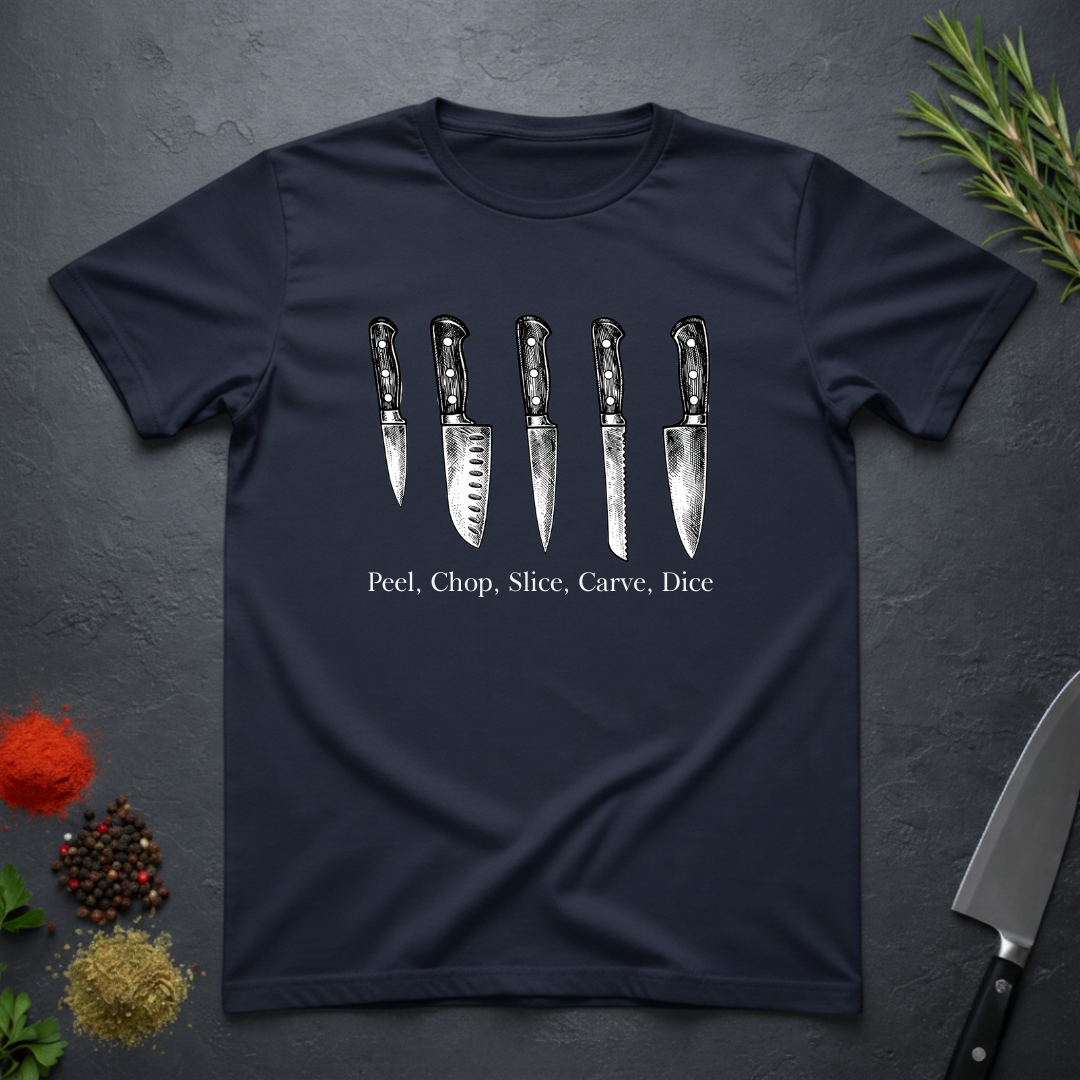 Navy blue t-shirt with knife graphic and text on a dark surface with kitchen items.
