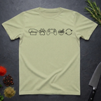 Pistachio green t-shirt with black icons of chef hat, paw print, game remote, ramen bowl and repeat symbol on a dark surface.