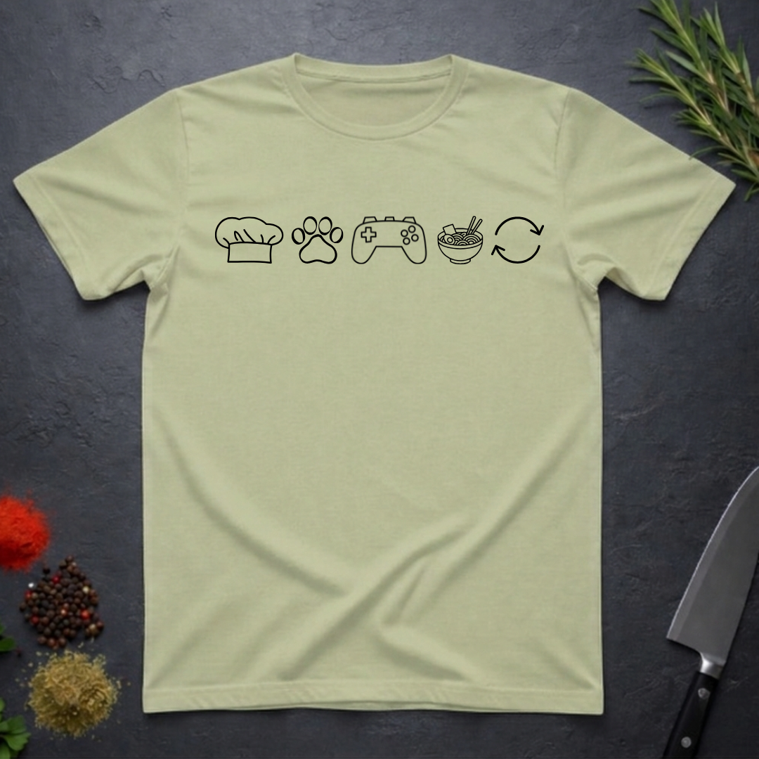 Pistachio green t-shirt with black icons of chef hat, paw print, game remote, ramen bowl and repeat symbol on a dark surface.