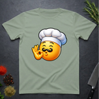 Sage Green t-shirt with a chef kiss emoji design on a dark surface with kitchen items.