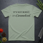 Sage Green t-shirt with black text on a dark surface with kitchen items.