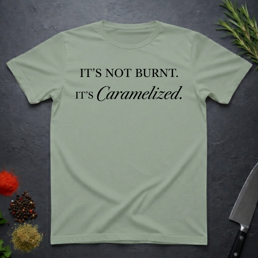 Sage Green t-shirt with black text on a dark surface with kitchen items.