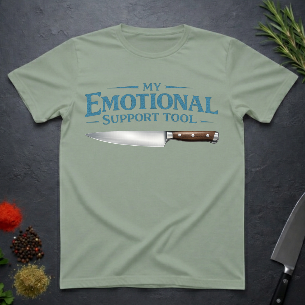 Sage Green t-shirt with a knife graphic and teal text "My Emotional Support Tool" on a dark surface.