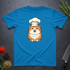 Sapphire Blue t-shirt with an orange cartoon cat wearing a chef's hat on a dark surface.