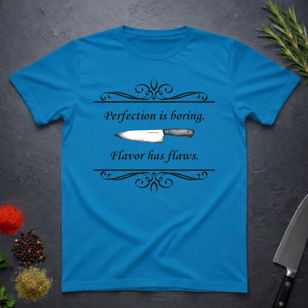 Sapphire Blue t-shirt with a knife graphic and text "Perfection is boring. Flavor has flaws." On a dark surface. 