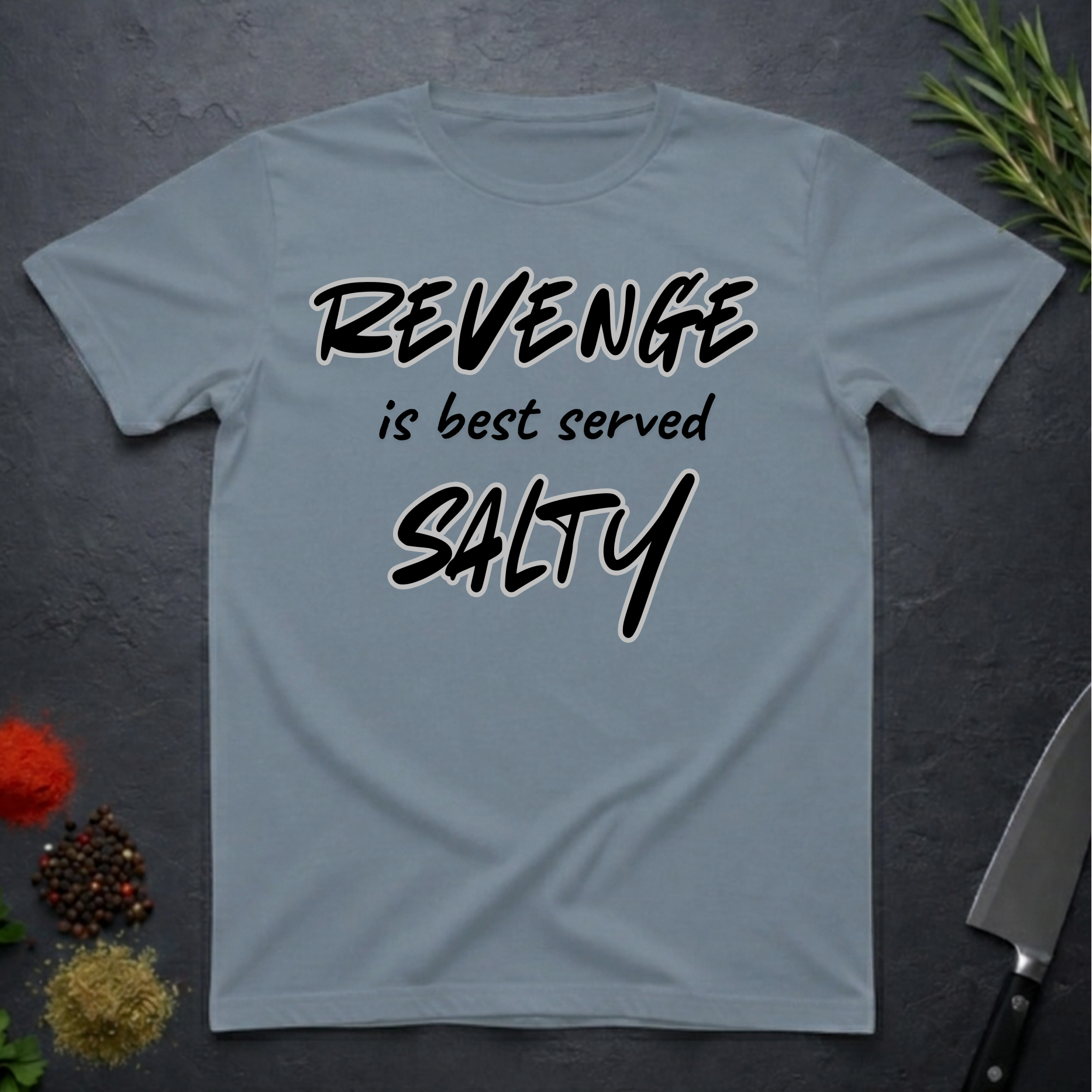 Stone Blue t-shirt with 'REVENGE is best served SALTY' text on a dark surface.
