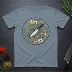 Stone blue t-shirt with a circular knife and colored floral design on a dark surface.