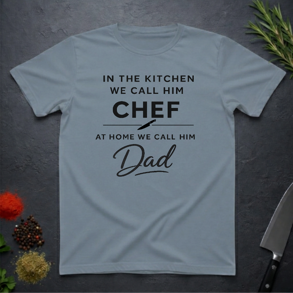 Stone blue t-shirt for Father's with text "In the kitchen we call him Chef - At home we call him Dad" on a dark surface.